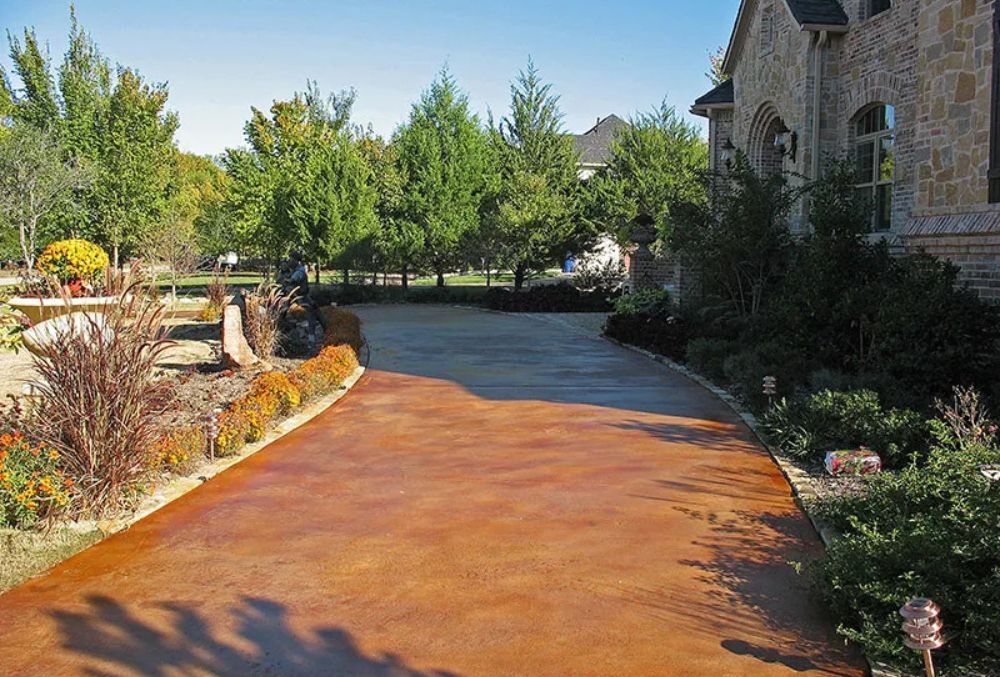 Stained concrete driveway with a smooth, colorful finish that adds style and durability to the home's exterior.
